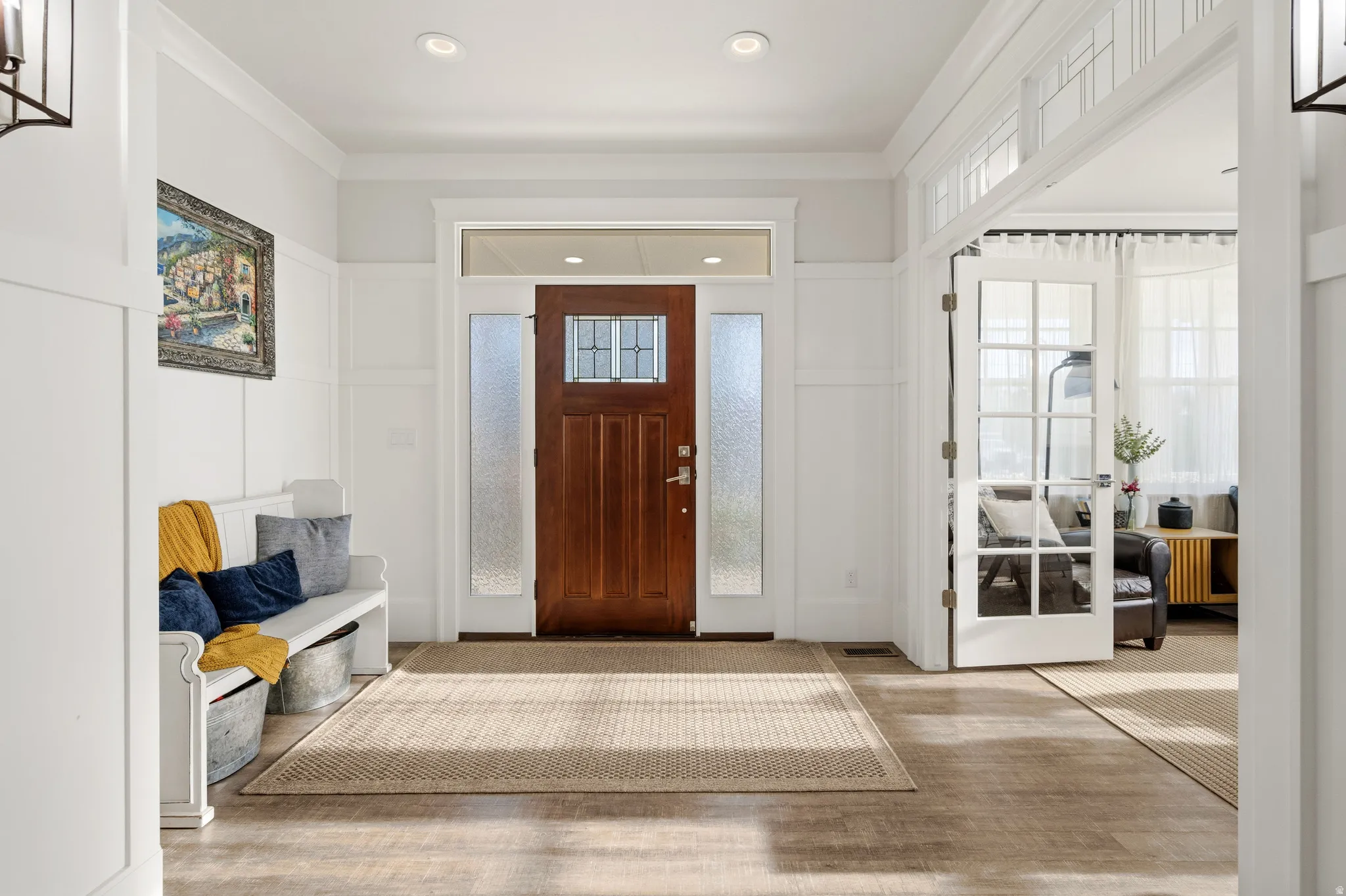 Wood-finish flooring throughout, featuring a rich wood entry door with glass panels