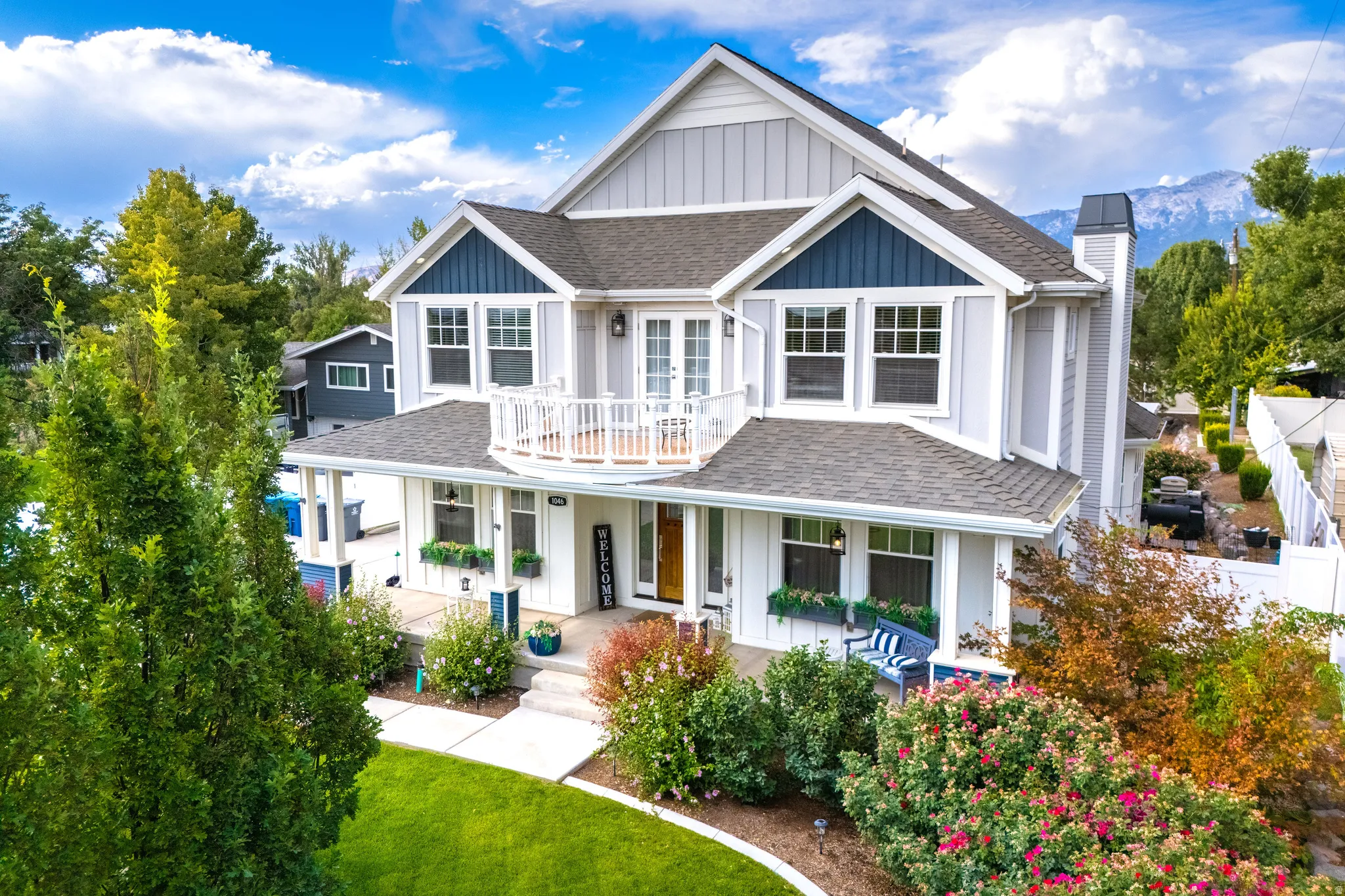 Two-story residence featuring light and dark siding, a covered porch, and a second-story balcony
