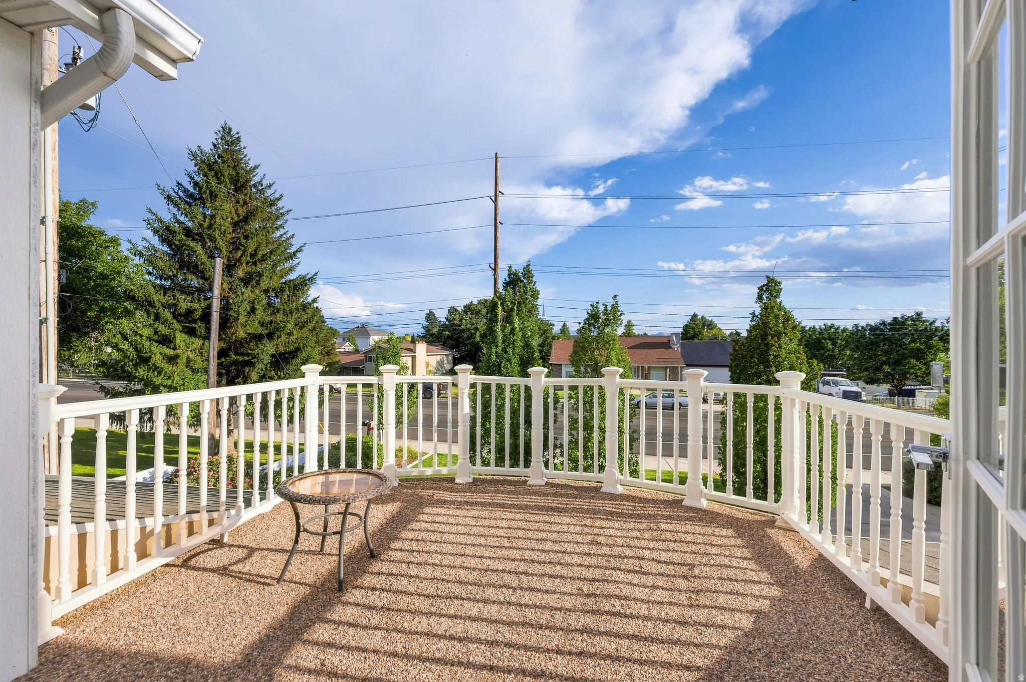 Balcony with white baluster railing and aggregate surface