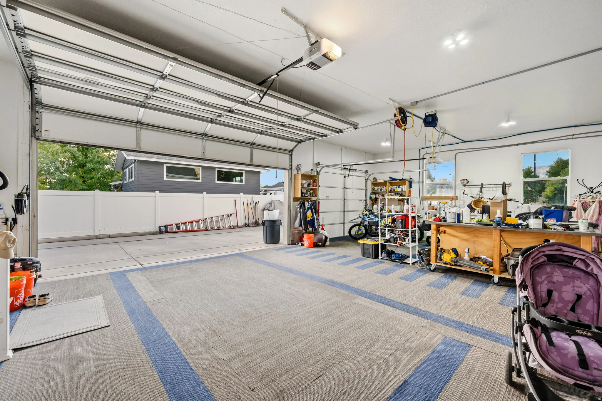 Attached garage with a sectional overhead door, patterned flooring, and recessed lighting