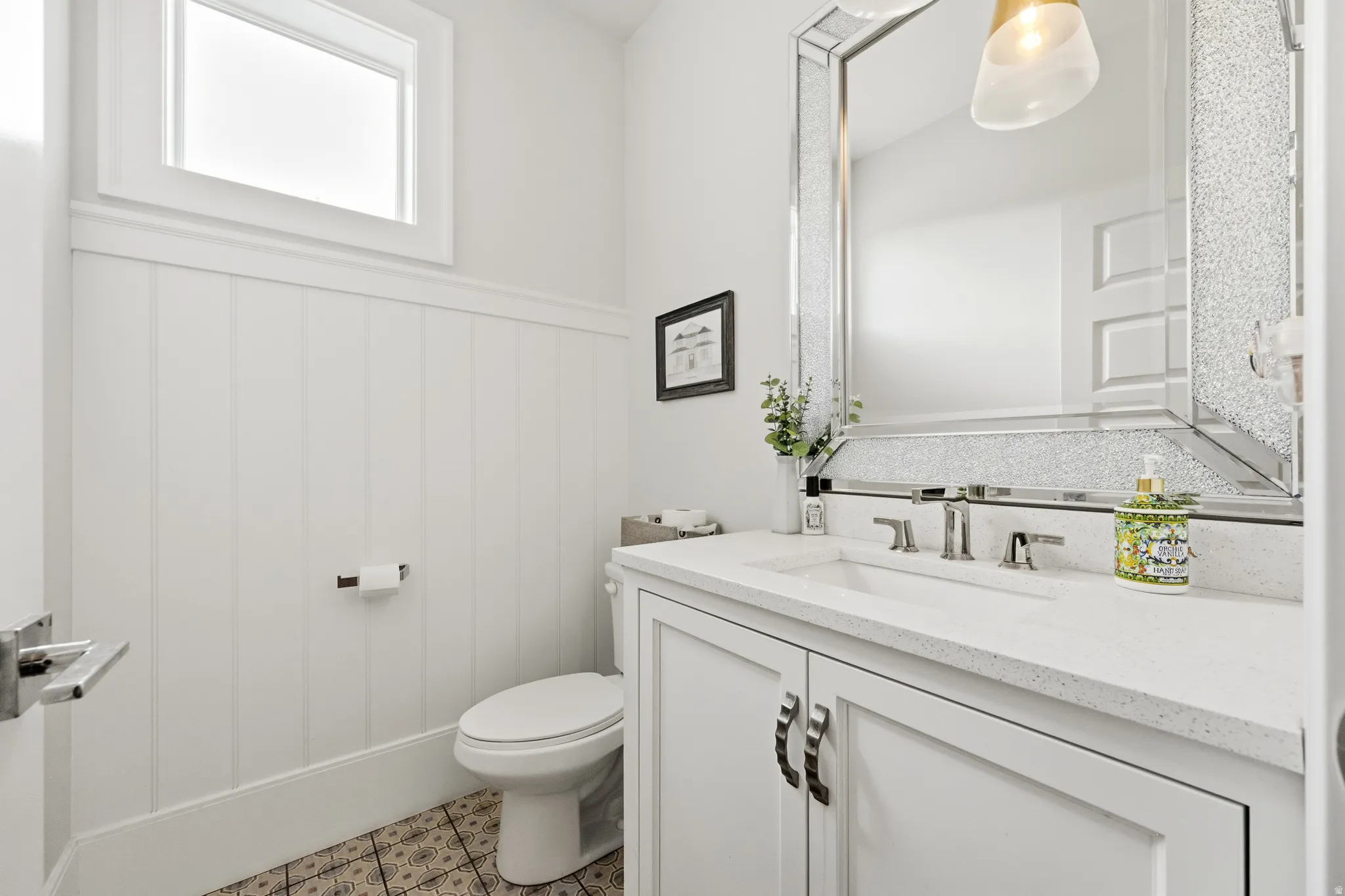 White vanity with integrated sink, polished chrome faucet, and quartz-finish countertop