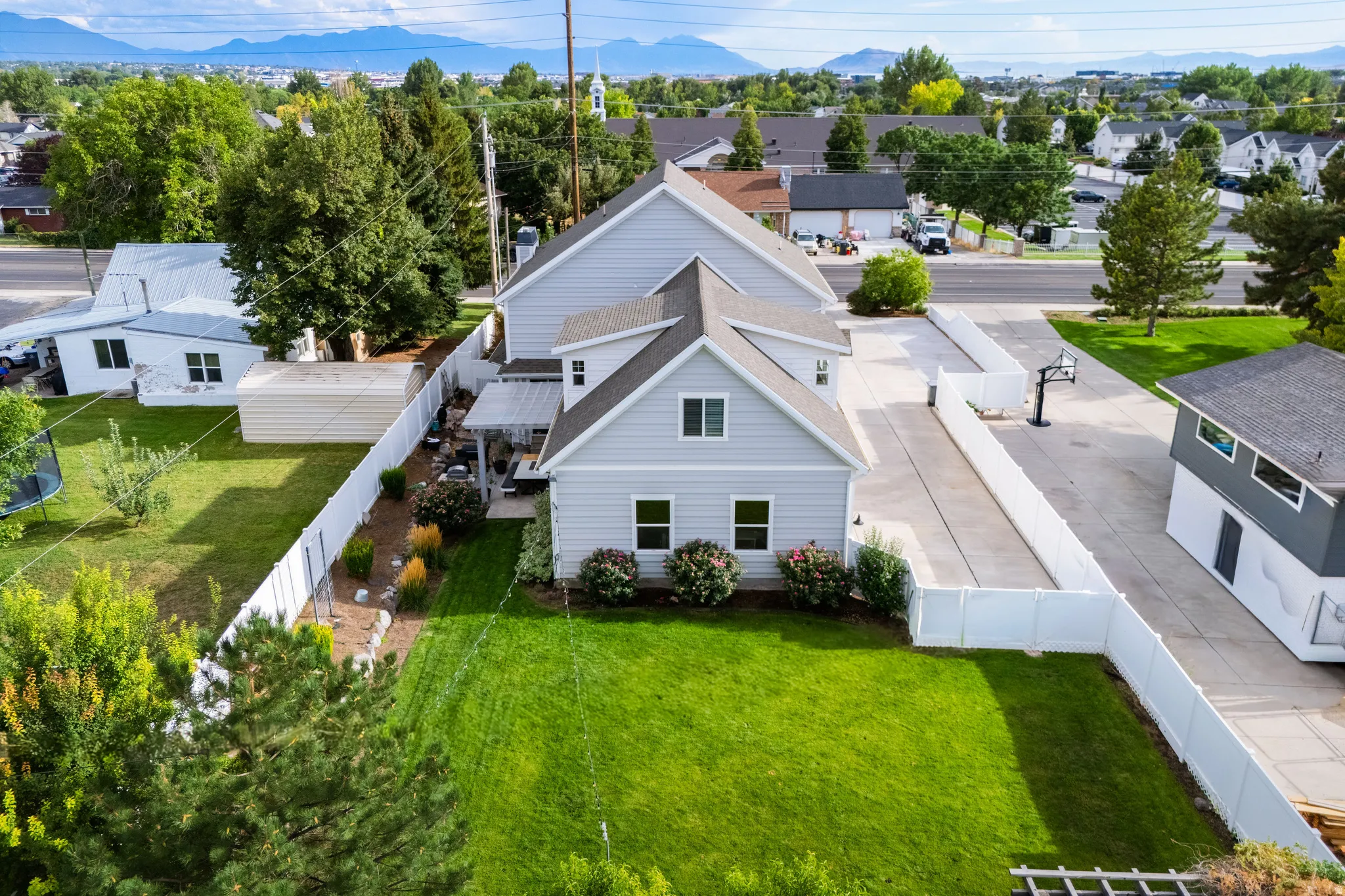 Expansive lawn area with a white privacy fence
