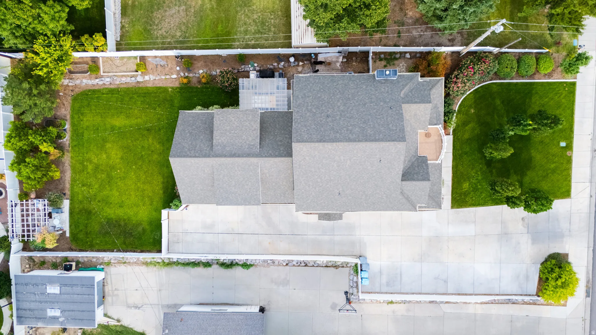 Expansive paved driveway, mature trees, and landscaping