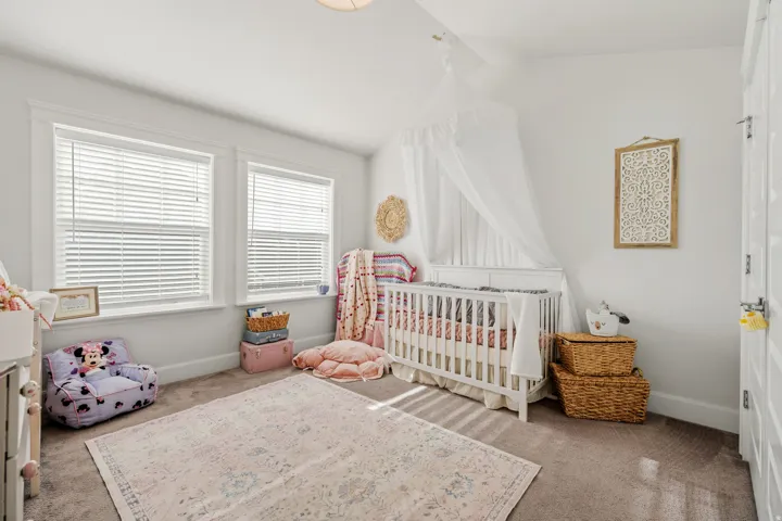 Two windows with blinds, white trim, and a white interior door