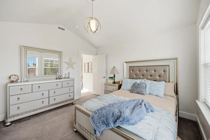 Vaulted ceiling, recessed lighting, double windows with blinds, wood-finish flooring, and a contemporary pendant light fixture