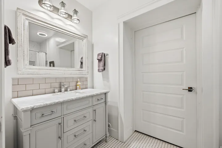 Vanity with a light gray finish, a rectangular undermount sink, and a stone-finish countertop