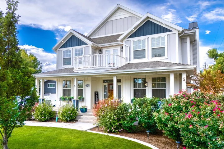 Two-story exterior with a covered porch, white column supports, and a second-level balcony