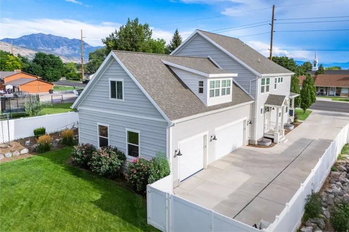 Two-story residence featuring light gray siding, a prominent two-car garage, and a covered front entry