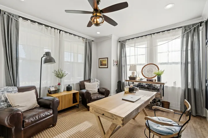 Recessed lighting, ceiling fan with integrated light, wood-finish flooring, multiple windows providing natural light, and crown molding