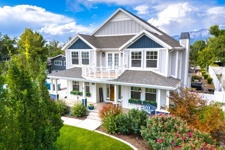 Two-story residence featuring light and dark siding, a covered porch, and a second-story balcony