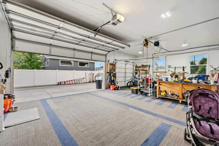 Attached garage with a sectional overhead door, patterned flooring, and recessed lighting