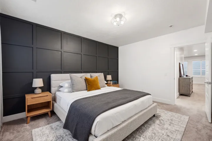 Accent wall with wainscoting detail, ceiling-mounted light fixture, and neutral carpeting