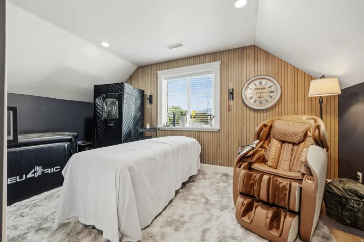 Sloped ceiling architecture with recessed lighting, shiplap accent wall, white-trimmed window, and plush carpeting