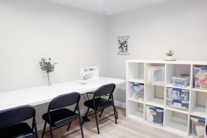 Light-toned wood-finish flooring, white walls, and a built-in white countertop workspace