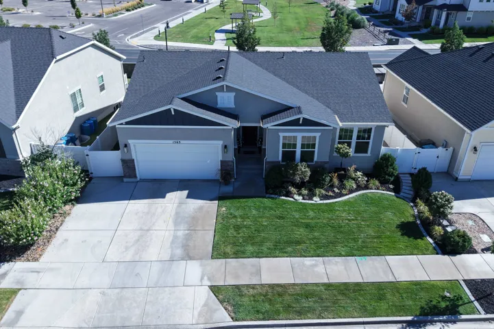 Single-story residence featuring a gray exterior, dark shingled roof, attached garage, and a concrete driveway