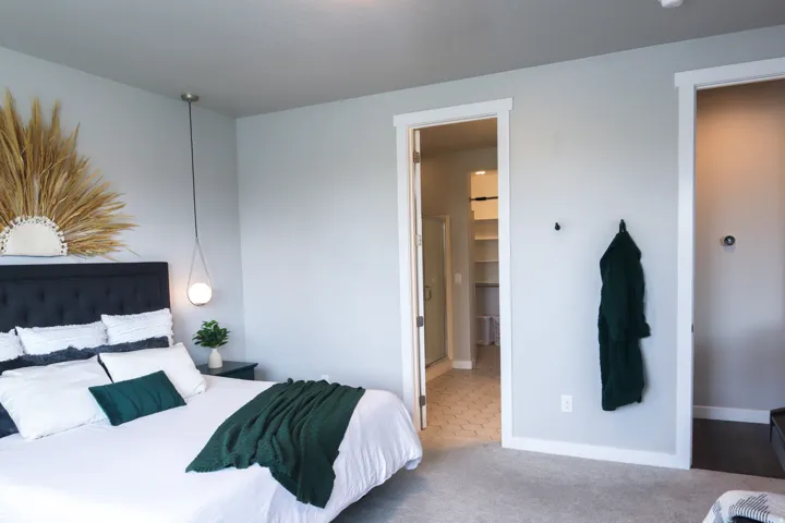 Neutral wall paint, pendant light fixture, carpeted flooring, built-in shelving, hexagonal floor tiles