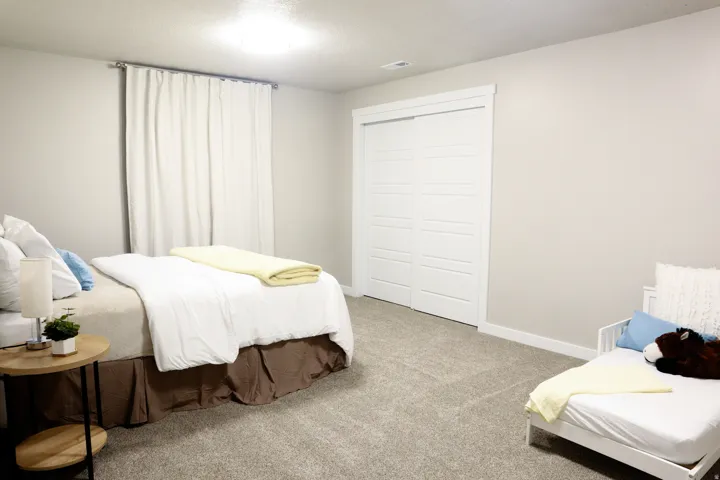 Plush carpet flooring, neutral paint palette, recessed ceiling light, and white sliding closet doors