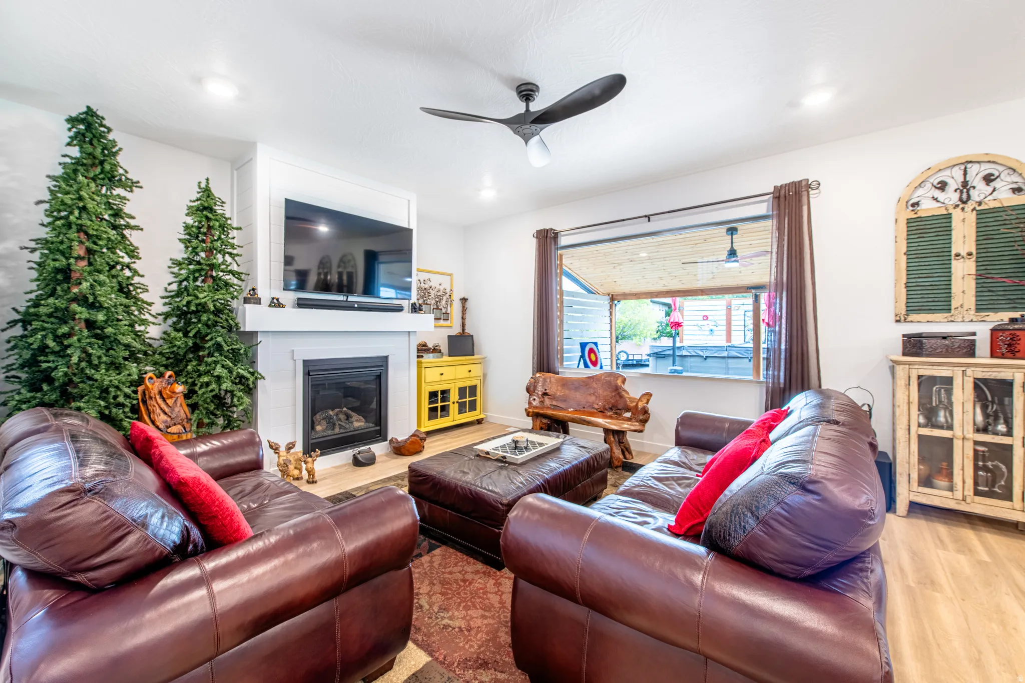 Fireplace with a white mantel, ceiling fan with integrated lighting, recessed lighting, and wood-finish flooring