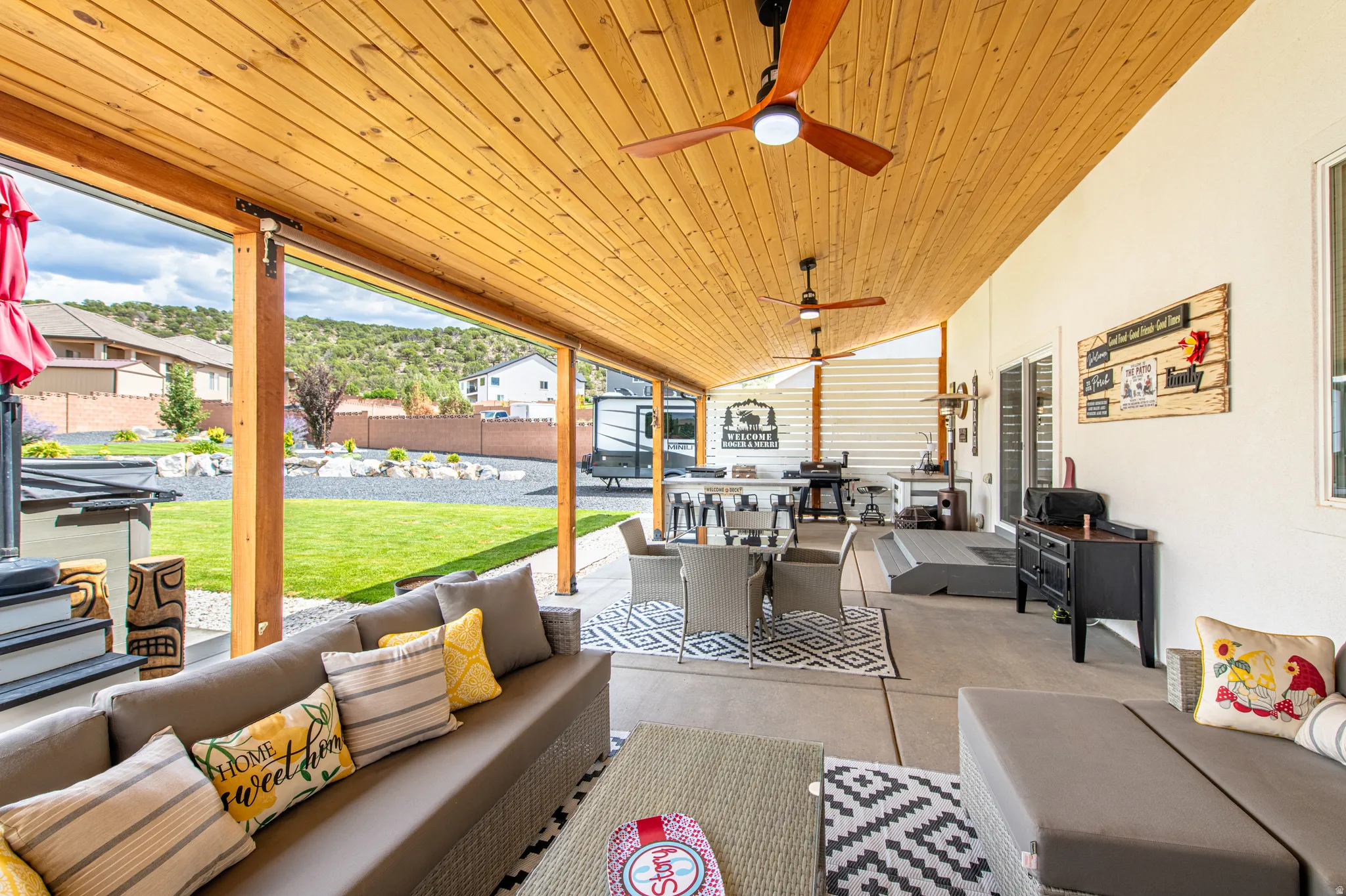 Expansive covered patio with wood-panel ceiling and multiple ceiling fans