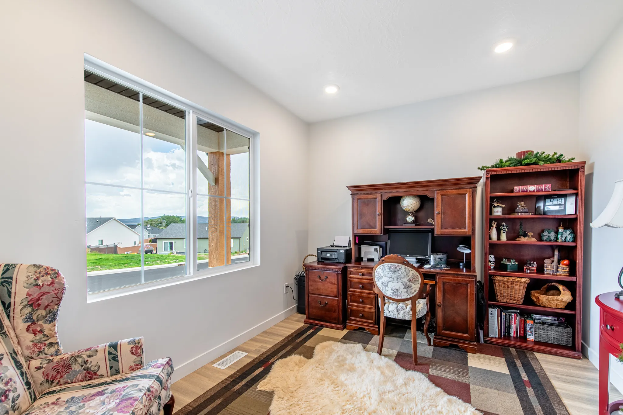Large window with multiple panes, wood-finish flooring, and recessed ceiling lighting