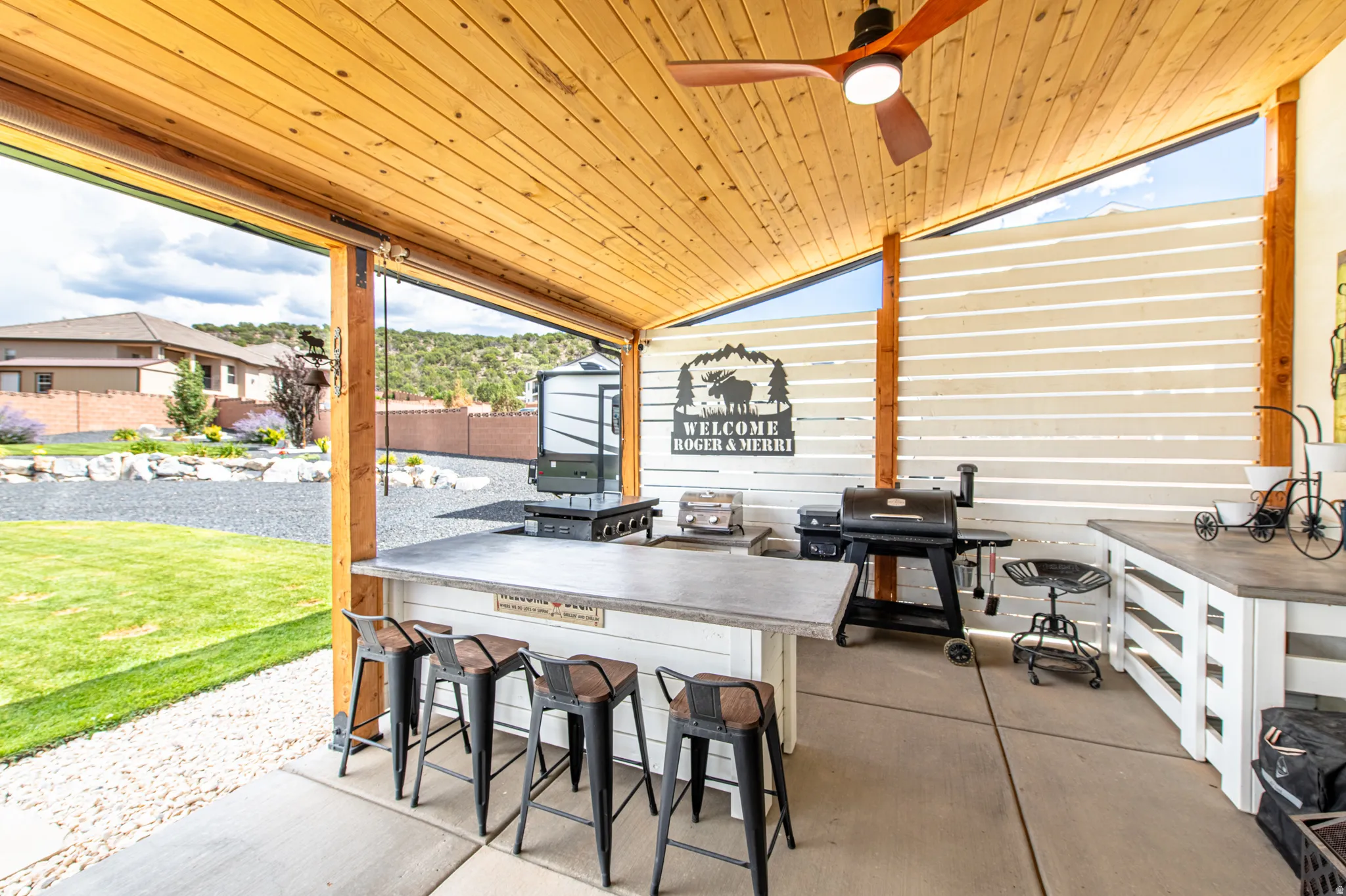 Covered patio with a wood-plank ceiling, ceiling fan, and concrete flooring