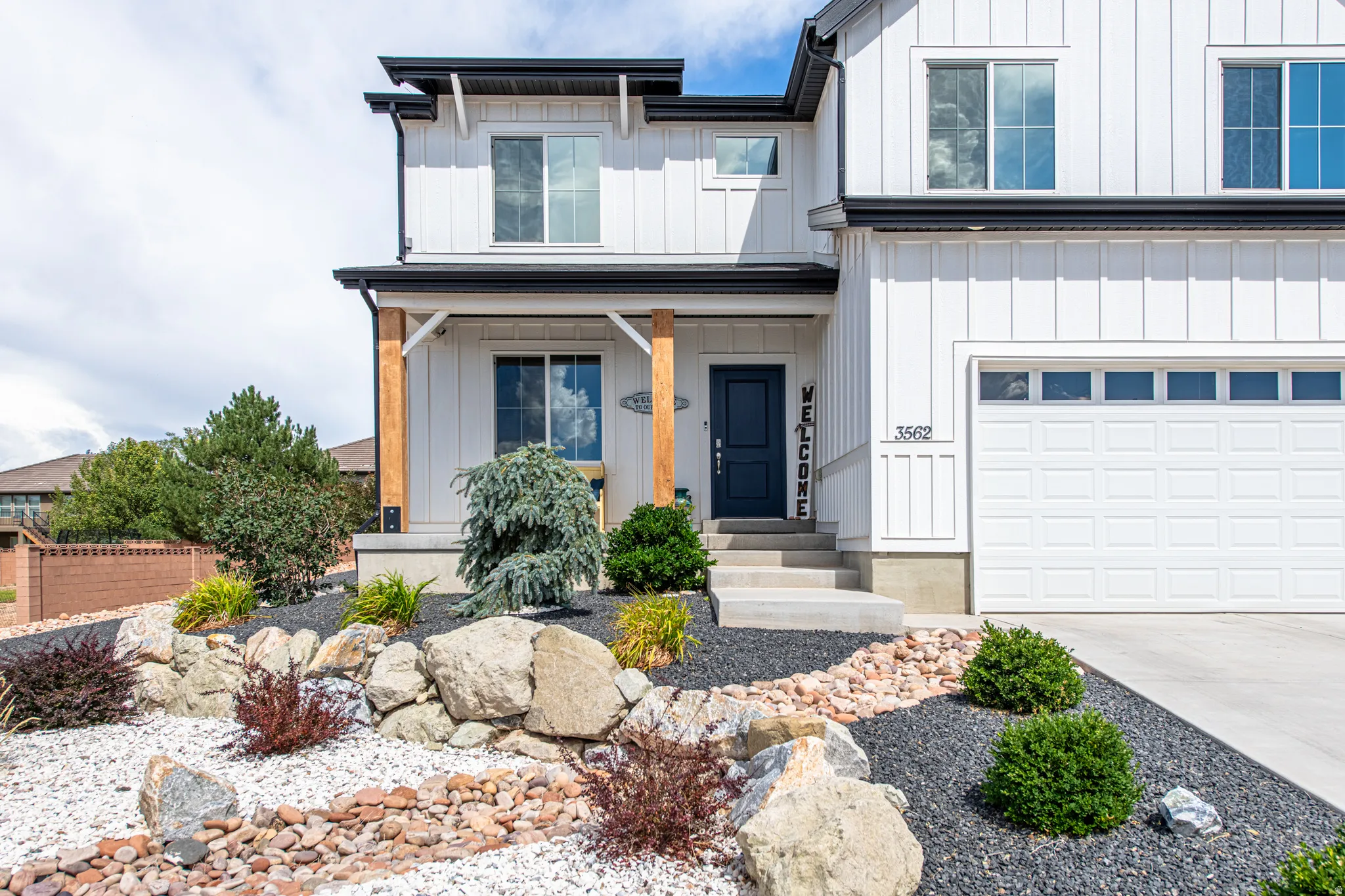 Modern farmhouse exterior with vertical white siding and black trim