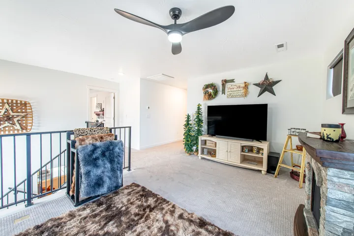 Upper-level area with carpeting and a modern ceiling fan with integrated lighting