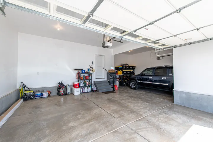 Spacious garage with concrete flooring, automatic garage door openers, and a separate utility area