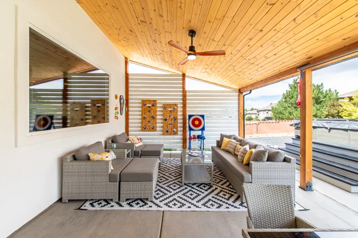 Covered patio with a wood-plank ceiling, ceiling fan, and concrete flooring