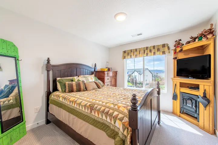 Wall-to-wall carpeting, window with outdoor scenery, recessed lighting, and a built-in corner entertainment unit with an electric fireplace insert