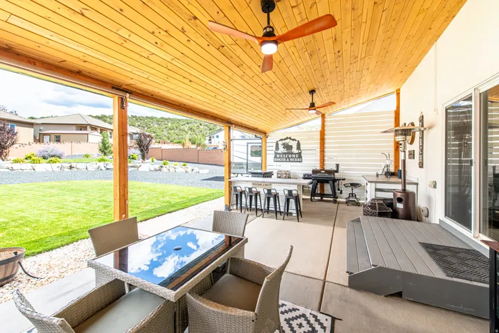 Covered patio with wood-finish ceiling, integrated ceiling fans, and concrete flooring