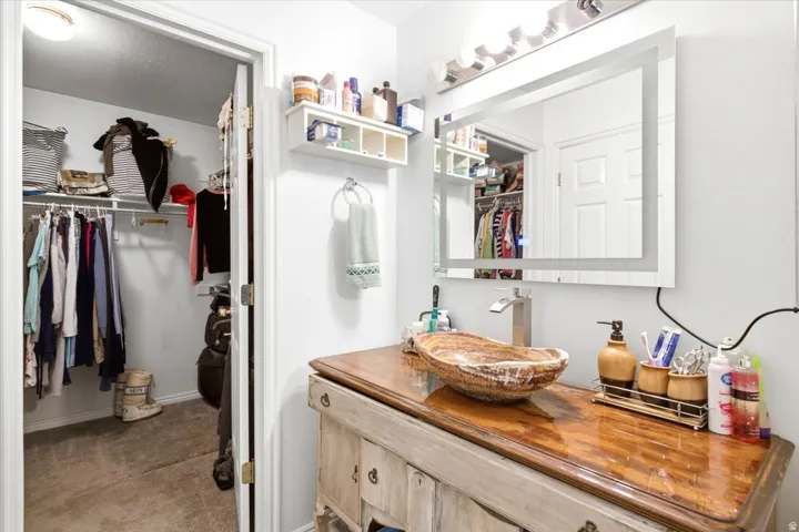Modern vanity with a natural wood-finish countertop and vessel sink