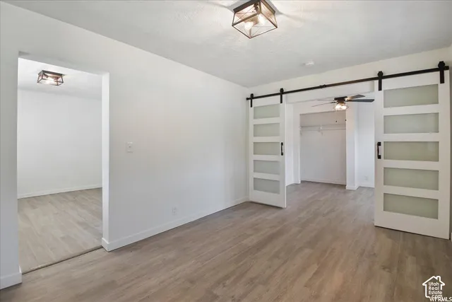 Wood-finish flooring, white sliding barn doors with frosted glass inserts, and square flush-mount light fixtures