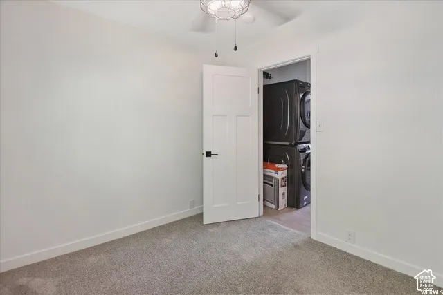 White walls, gray carpet, white trim, and a ceiling fan with integrated lighting