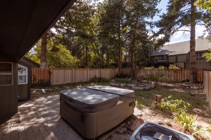 Backyard featuring a wood deck, hot tub, and wood privacy fence