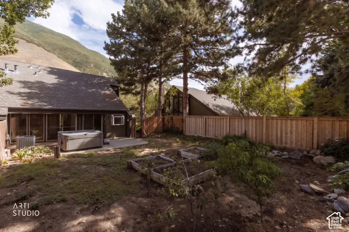 Rear exterior with concrete patio, sliding glass doors, and a partial privacy fence