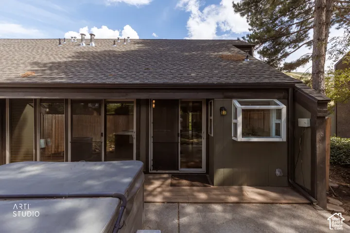 Sliding glass doors leading to an outdoor patio with concrete paving