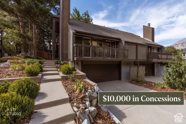 Multi-level facade with balconies, attached garage, and a tiered concrete walkway