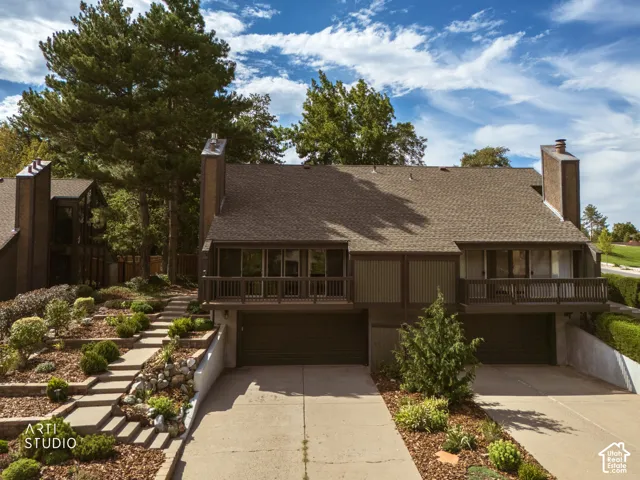 Multi-level exterior with a shingle roof and prominent chimneys