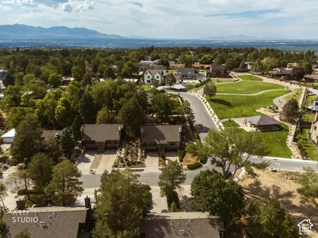Green space with walking paths, paved roadways, and a distant mountain backdrop