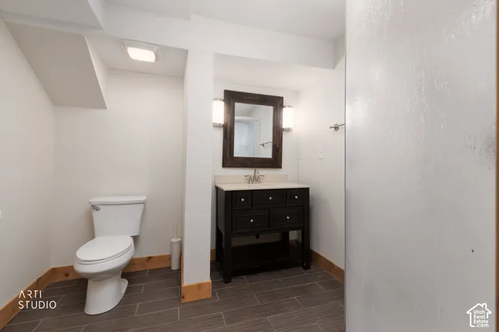 Dark wood-finish vanity with a light countertop, rectangular mirror, and dual sconce lighting