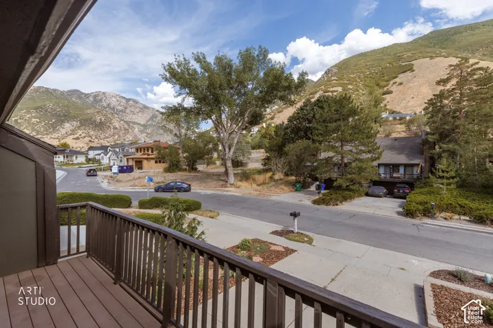 Deck with wood-finish decking and dark railings, featuring a mountain backdrop
