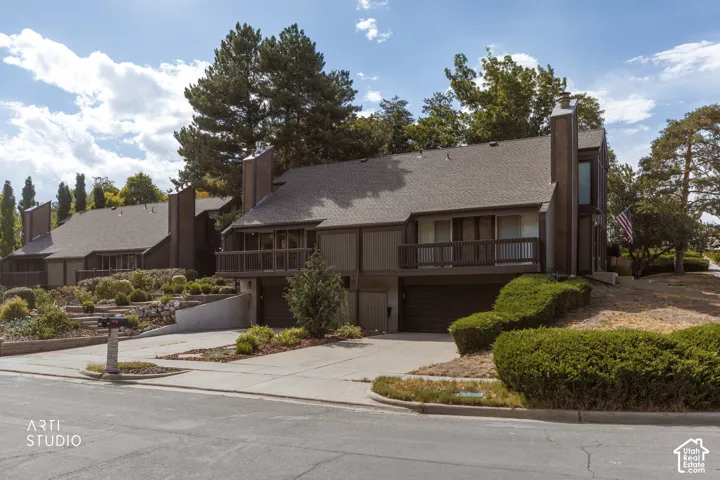 Multi-level property with a shingle roof and a prominent chimney