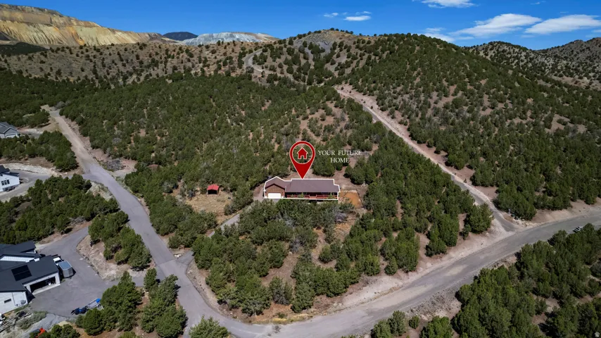 Brown-toned residence with an attached garage, set amidst extensive natural landscaping and a mountain backdrop