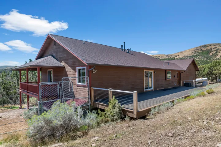 Expansive exterior deck with wood-finish siding, covered porch, and white-framed windows