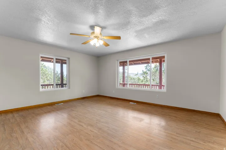 Spacious room featuring wood-finish flooring and two large windows