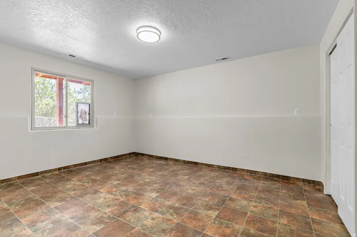 Tile flooring, neutral wall tones, modern flush mount ceiling light, and a white paneled door