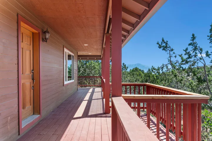 Expansive covered porch featuring wood flooring, wood siding, and painted wood railings