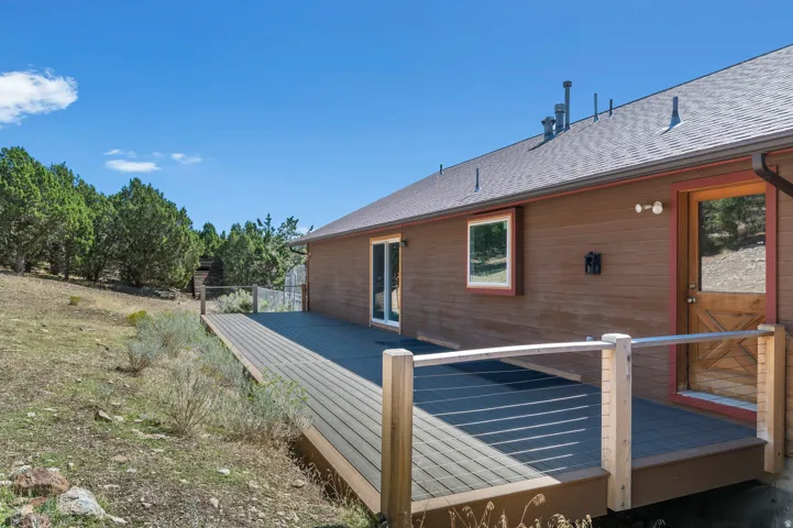 Expansive outdoor deck featuring composite decking, wood-finish railing posts, and metal handrails