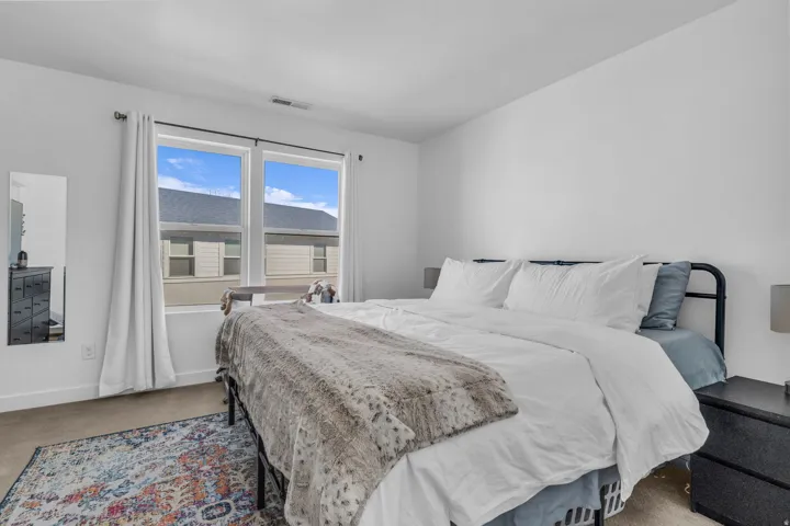 Expansive windows with white trim, light-colored walls, and neutral carpeting